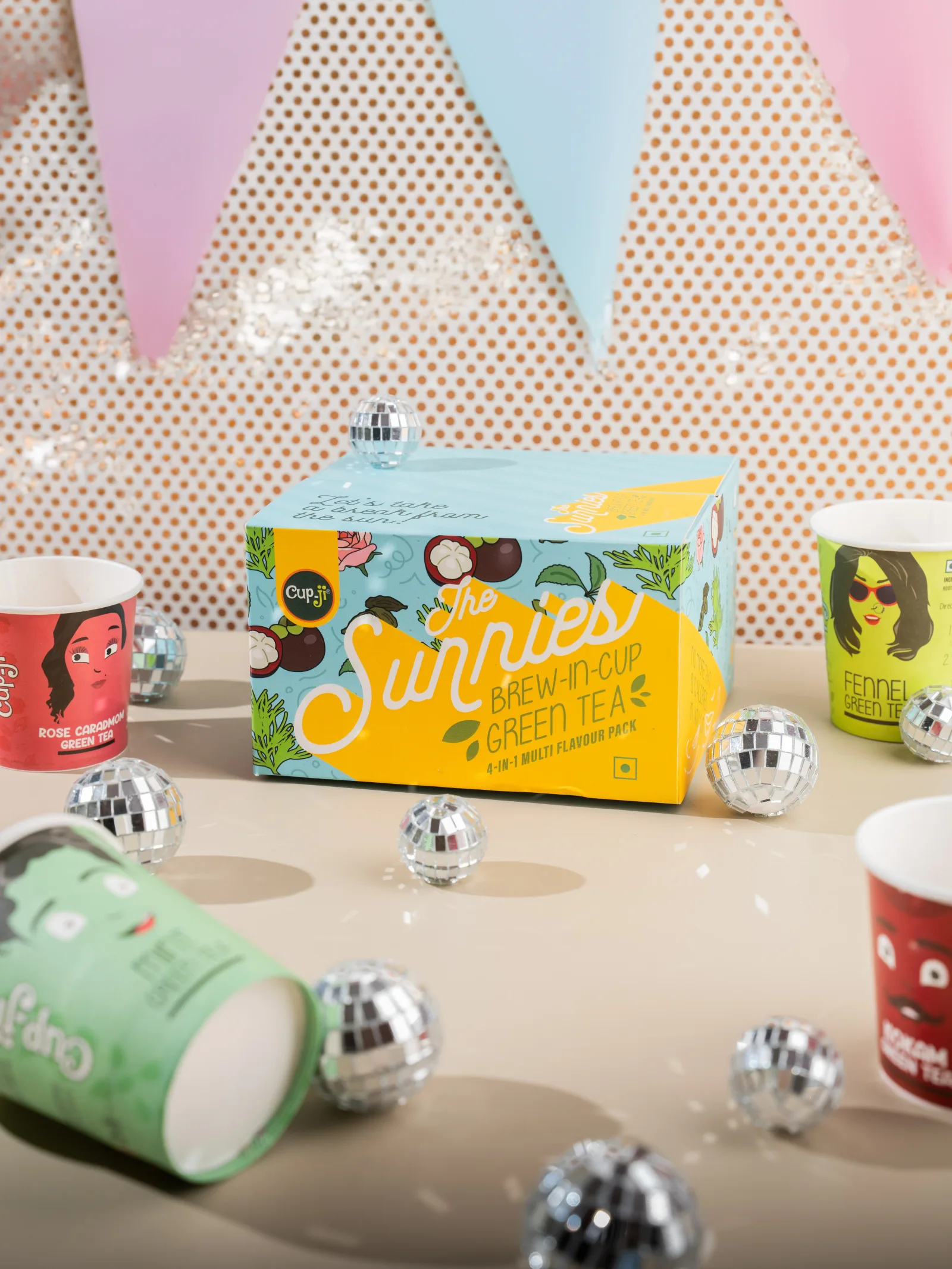 The Sunnies gift box against party bunting, confetti and hanging disco balls.