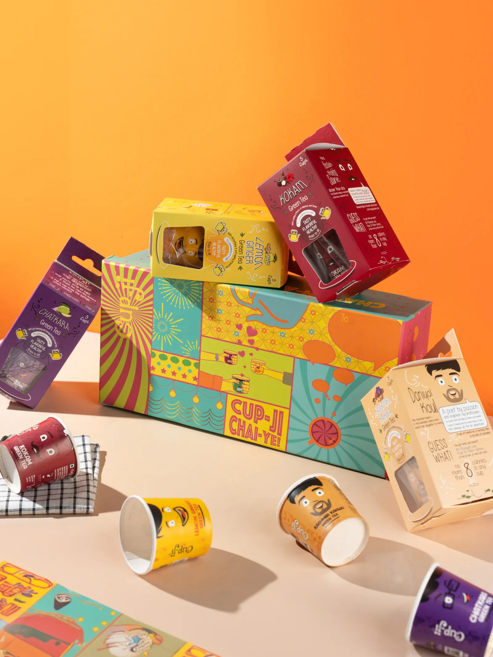 Overhead flatlay of the open Chai-ye gift box with its four flavour packs, cups and citrus laid around it.
